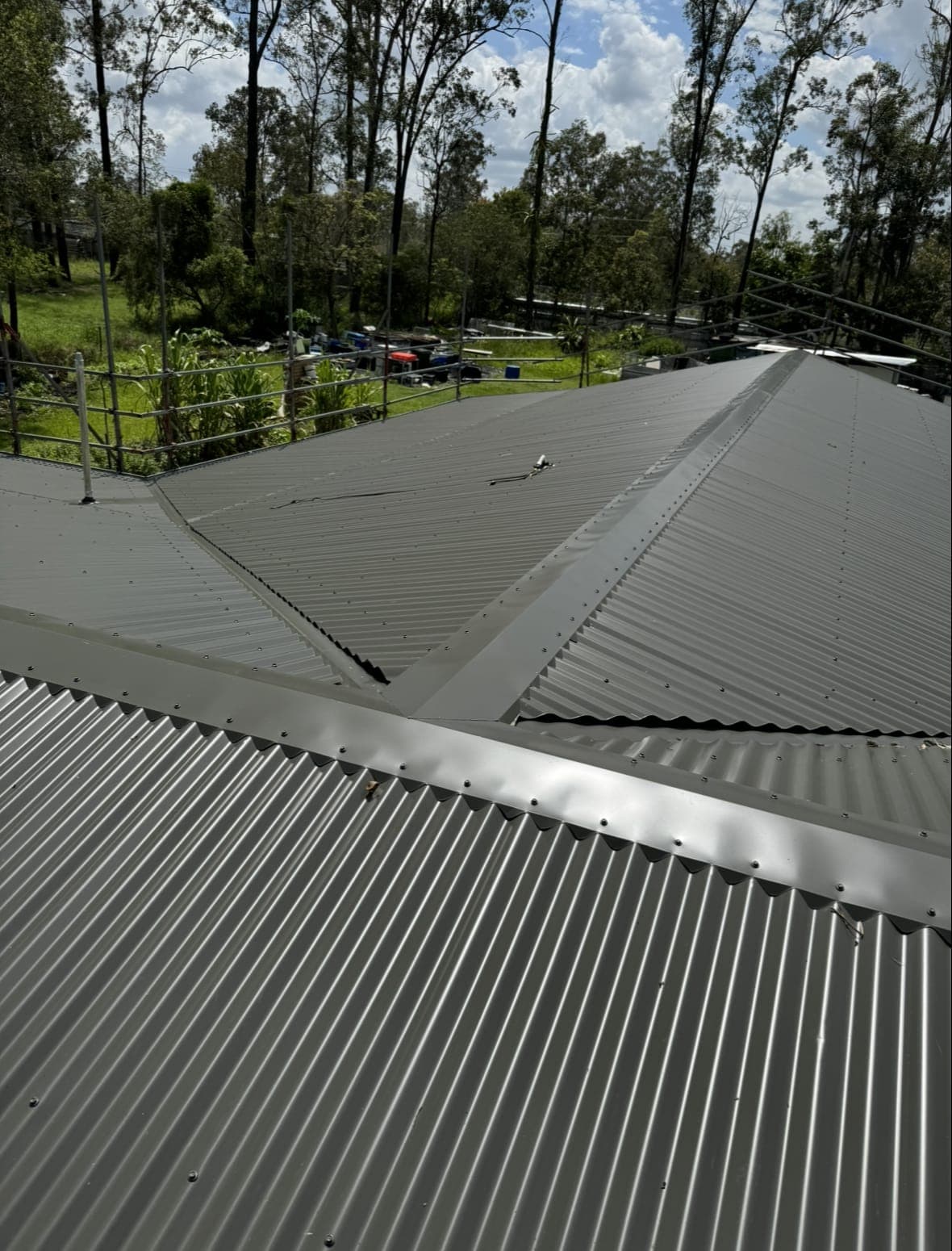 Dark grey Colorbond roof ridge and sheets with bushland behind