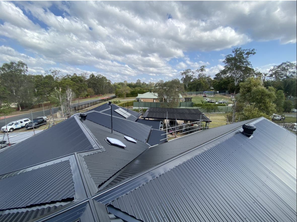 Wide view of a new dark Colorbond roof with skylights and valleys