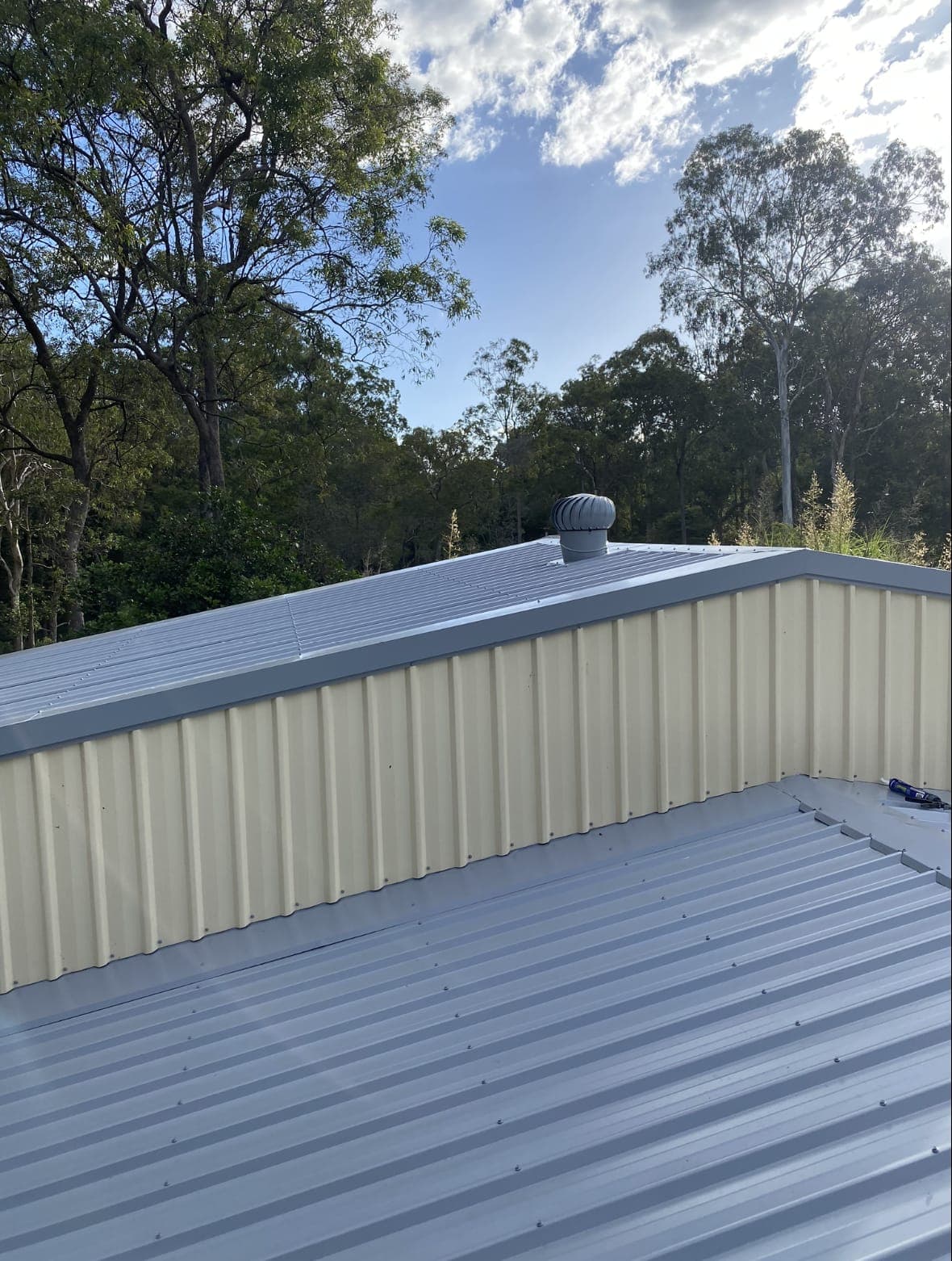 Grey Colorbond roof meeting cream wall cladding